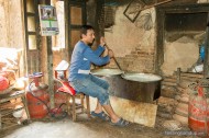man stirring pot of milk