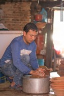 man rinsing clay pots